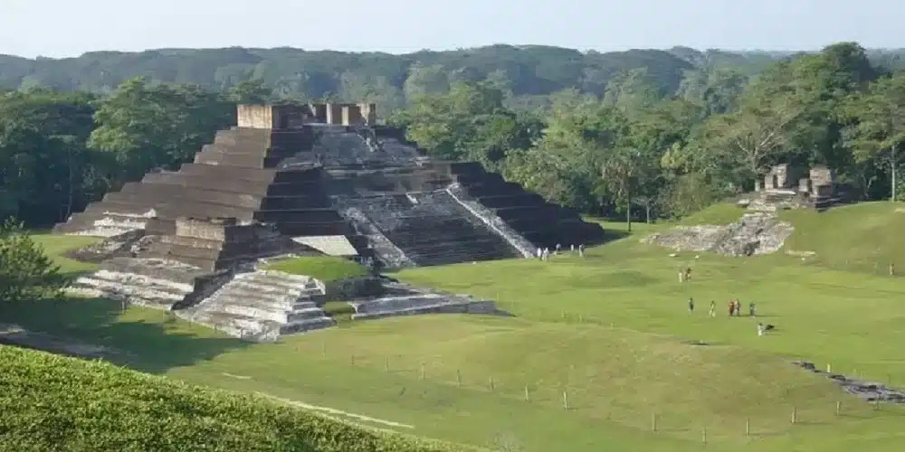 Zona arqueológica de Comalcalco con estructuras prehispánicas de ladrillo rodeadas de vegetación tropical.